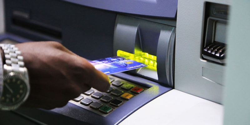 a client using atm to withdraw his money in kigali